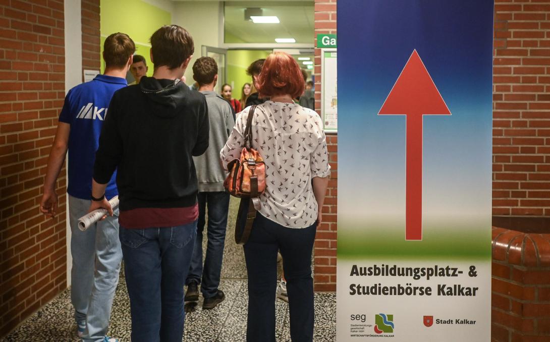 Besucher der top4theJob auf dem Weg zu den Ausstellungsräumen Besucher der top4theJob und Roll-up mit Richtungspfeil im Pädagogischen Zentrum